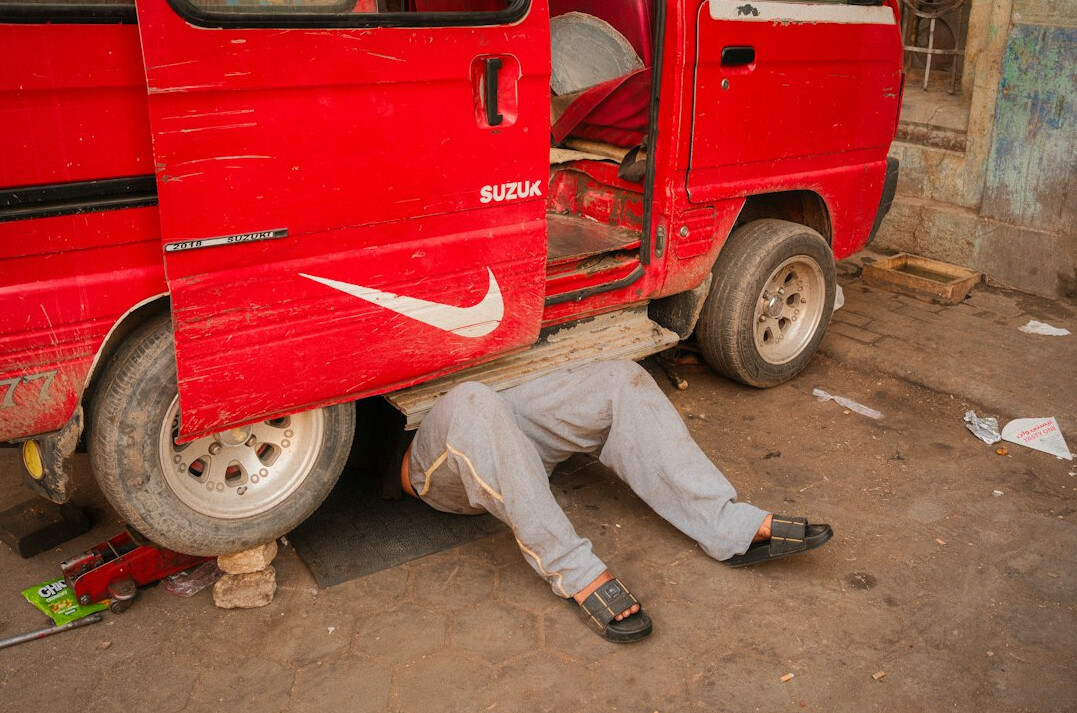 Mechanic inspecting the underside of a car in a garage